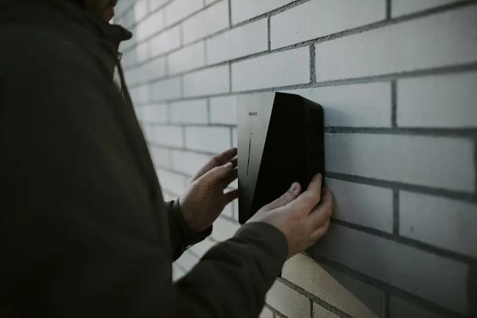 installateur plaatst contactdoos laadpaal aan de muur