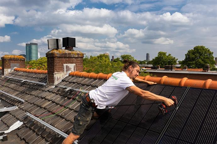 groenpand monteur installeert zonnepanelen op schuin dak