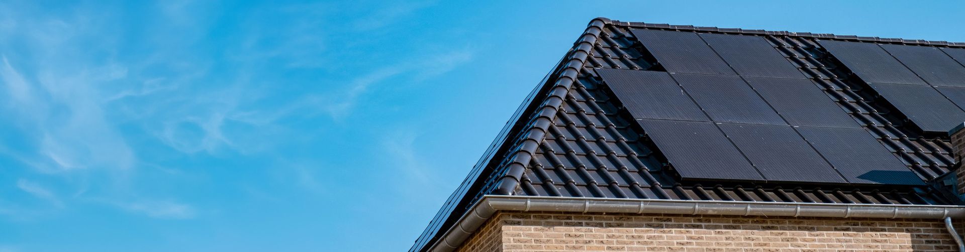 dak met zonnepanelen tegen blauwe lucht