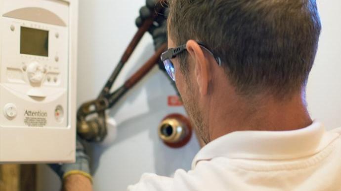 groenpand warmtepomp monteur draait een knop aan