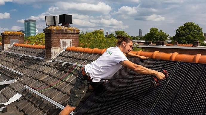 groenpand monteur installeert zonnepanelen op een schuin dak