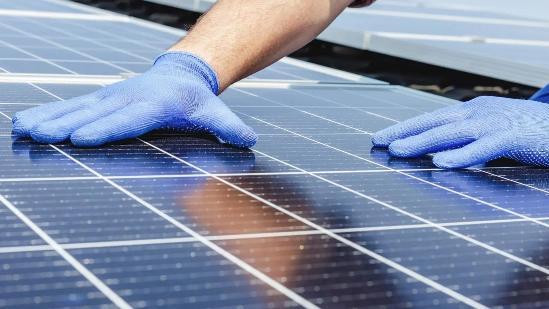 monteur controleert een zonnepaneel op schade